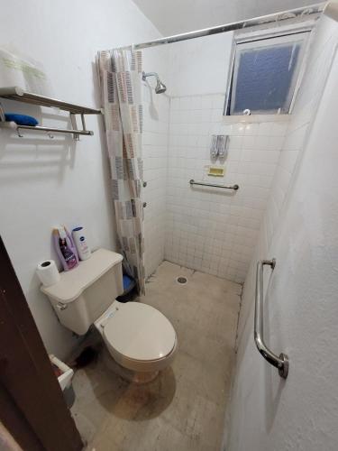 a small bathroom with a toilet and a shower at Liz in Matehuala