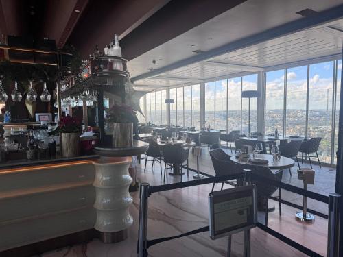 a restaurant with tables and chairs and large windows at Mercury Tower Apt 508 in St. Julianʼs