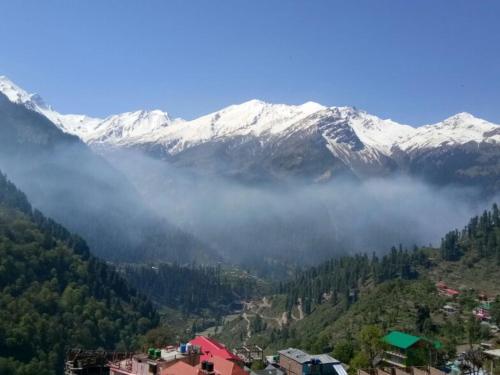Blick auf einen Berg mit schneebedeckten Bergen in der Unterkunft The Hosteller Kasol, Parvati Valley in Kasol