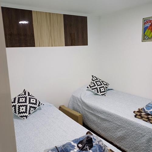 2 aparte bedden in een kamer met witte muren bij Tiny Tunquen in Valparaíso