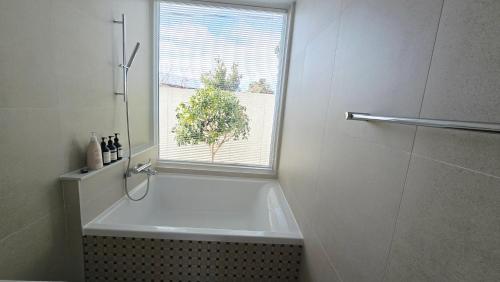 a bathroom with a bath tub and a window at 유유히 in Sowang-dong