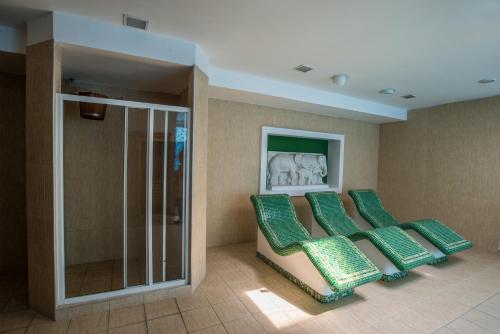 a row of green chairs in a waiting room at Mercure Medias Binderbubi Hotel And Spa in Mediaş