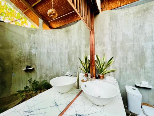ein Badezimmer mit zwei Waschbecken und zwei Toiletten in der Unterkunft Bamboo Cottages in Phu Quoc