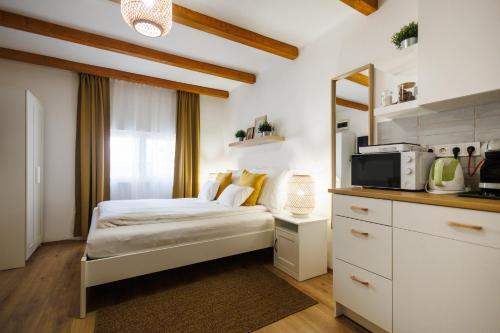 une petite chambre avec un lit et un micro-ondes dans l'établissement Murányi Vendégház, à Mórahalom