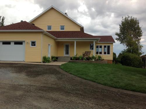 a yellow house with a white garage at Domaine sur une plage in Saint-Félicien