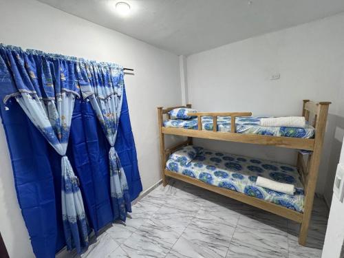 een kamer met 2 stapelbedden en blauwe gordijnen bij Apartamento en Riohacha in Ríohacha