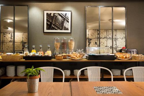 a table with chairs and a buffet with food at Hotel Espace Champerret in Levallois-Perret