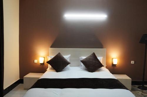 een slaapkamer met een groot wit bed met twee kussens bij Herat Star Hotel in Herat