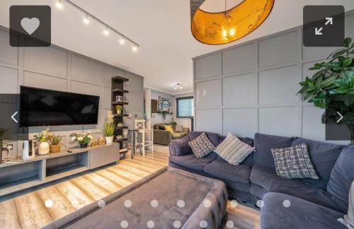 a living room with a couch and a tv at Luxury 2 BR Flat in Canary Wharf in London