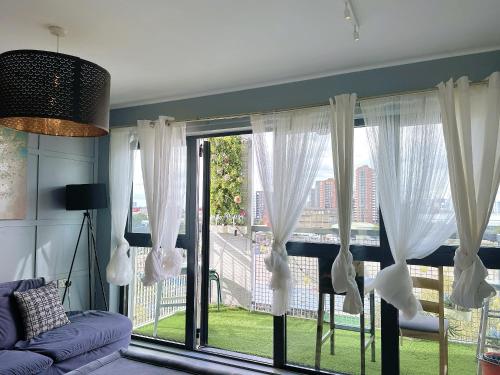 a living room with a large window with white curtains at Luxury 2 BR Flat in Canary Wharf in London
