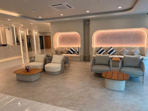 a waiting room with couches and chairs and a table at Aston Hotel Pattaya in Pattaya