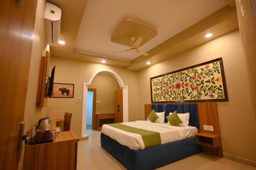 a bedroom with a bed with a painting on the wall at The Van Bagh Ranthambore in Sawāi Mādhopur
