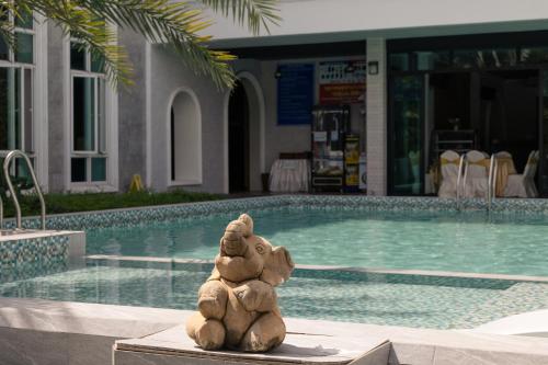 due orsacchiotti seduti accanto a una piscina di Le Erawan Phang Nga Hotel a Phang Nga