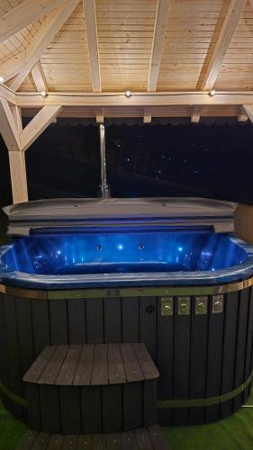 une grande baignoire bleue installée au-dessus d'une terrasse dans l'établissement Cabana Murmur de Padure, à Bălnaca