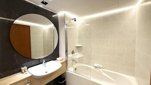 a bathroom with a sink and a mirror and a tub at Trinity Holiday Homes - Sheikh Zayed Road Right Next to Financial Center Metro Station Exit 1 in Dubai