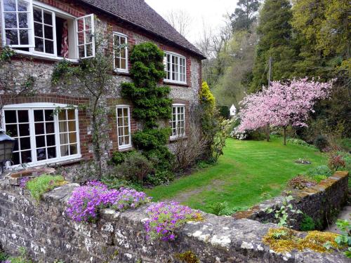 a stone house with flowers in front of it at Bridge Cottage in Midhurst