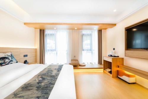Postel nebo postele na pokoji v ubytování Huangshan Danqing Elegant Garden Smart Vacation Villa Boutique Guesthouse