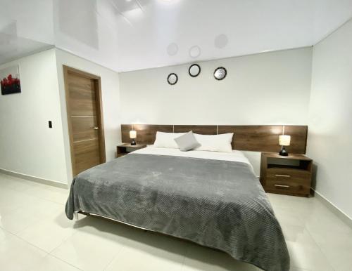 a bedroom with a large bed and two night stands at Suite Matrimonial 3plz con cocina y garage in Baños