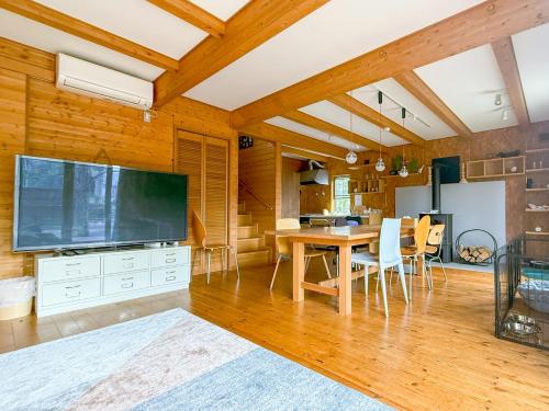 a living room with a large television and a table at yado suzuka in Suzuka