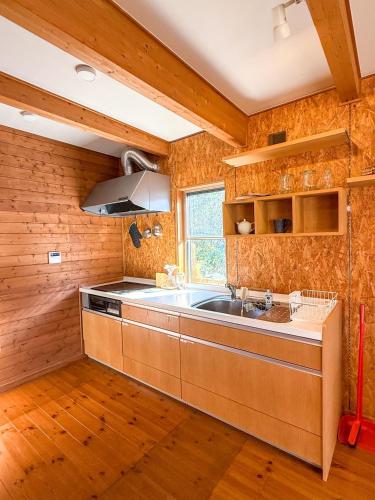 a kitchen with wooden walls and a sink and a window at yado suzuka in Suzuka