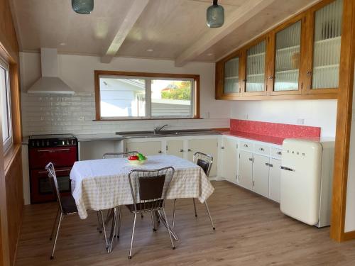 a kitchen with a table with chairs and a sink at Ocean Breeze Holiday Home in Riverton