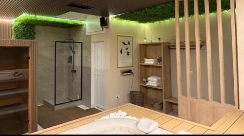 a bathroom with a tub and a shower with green plants at Monte LUX 10 in Kopaonik