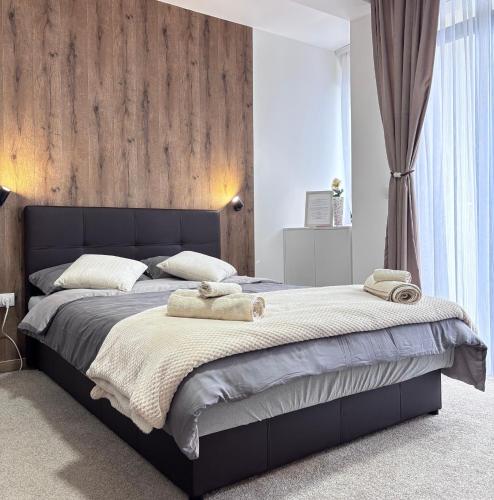 a bedroom with a large bed with two towels on it at Monte LUX 10 in Kopaonik