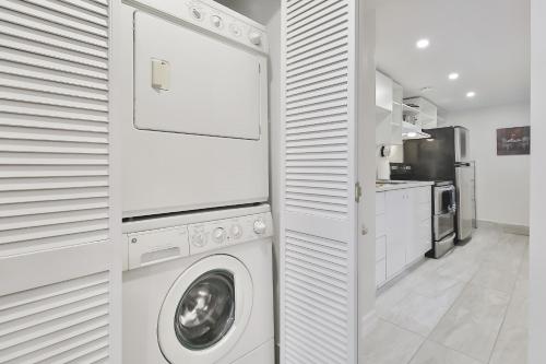 a white laundry room with a washer and dryer at FREE PARKING - 5 minute walk to METRO STATION Berri Uqam - In-Suite WASHER & DRYER - fully stocked KITCHEN - WORKSPACE PROVIDED - FAST WIFI in Montréal