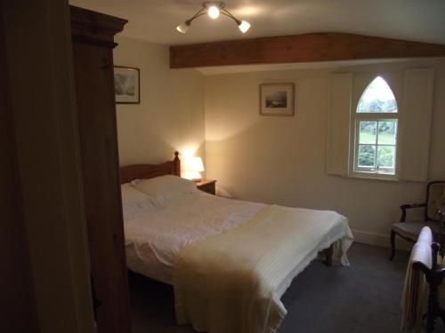 a bedroom with a white bed and a window at Glyn Arthur Lodge in Llandyrnog