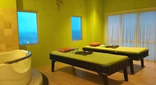 - 2 lits dans une chambre dotée de murs verts et de fenêtres dans l'établissement Horison Ultima Semarang, à Jomblang