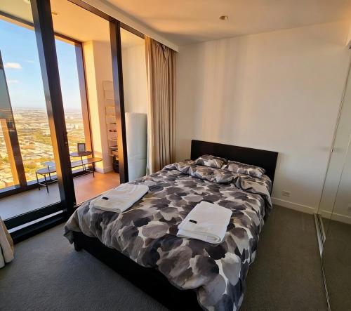 a hotel room with a bed and a large window at Sunset Sky Nest CBD 65F in Melbourne