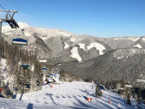 a ski lift on top of a snow covered mountain at Apartmán Vila Zuberec in Zuberec