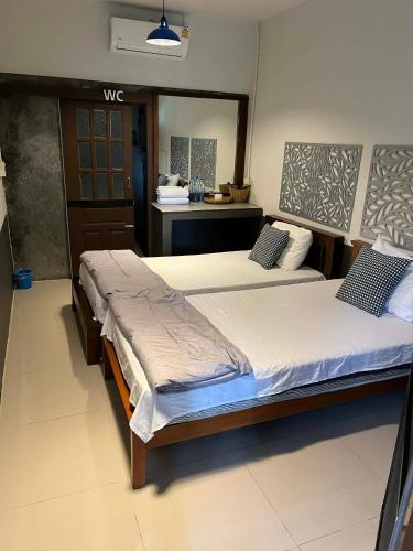 two beds sitting next to each other in a bedroom at Suandok History House in Chiang Mai