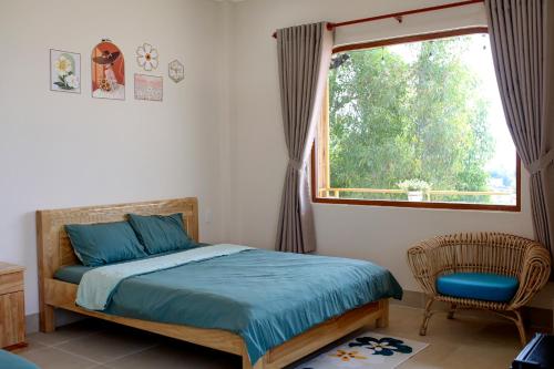 a bedroom with a bed and a window and a chair at The Sky Homestay in Ấp Khánh Phước (1)