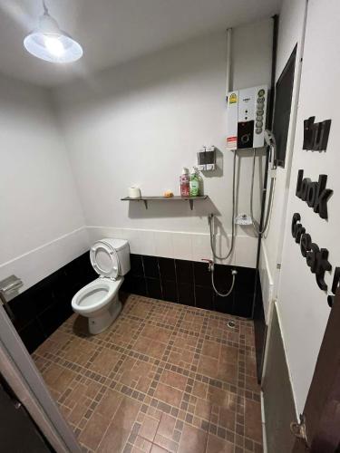 a small bathroom with a toilet and a shower at Suandok History House in Chiang Mai