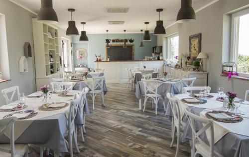 jadalnia z białymi stołami i białymi krzesłami w obiekcie Agriturismo Poggio Alle Serre w mieście Gallinaro