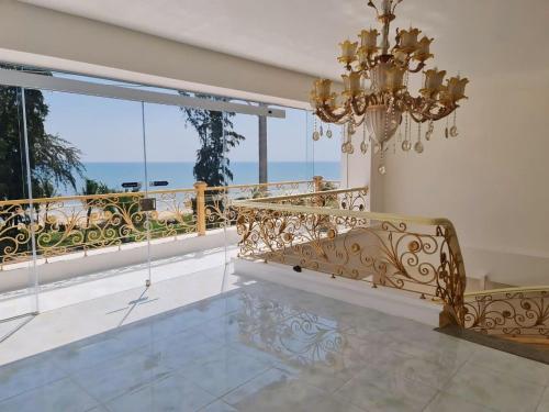 a room with a chandelier and a balcony at Ruby Hotel Front Of Beach 2 in Bình Sum