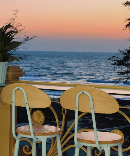 a table and two chairs with the ocean in the background at Ruby Hotel Front Of Beach 2 in Bình Sum