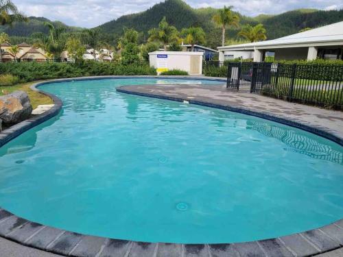 ein großer Pool mit blauem Wasser im Hof in der Unterkunft Villa 46 in Pauanui