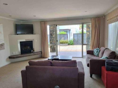 ein Wohnzimmer mit zwei Sofas und einem Kamin in der Unterkunft Villa 46 in Pauanui