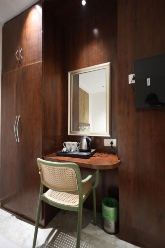 een tafel met een spiegel en een stoel in een kamer bij Hotel Destin in Gwalior