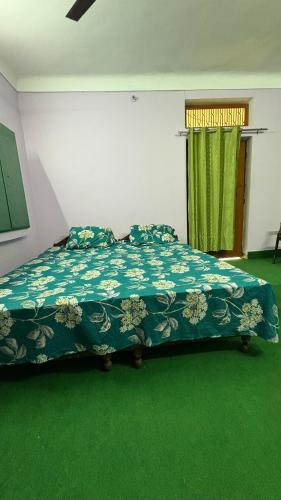 a bedroom with a bed with a green carpet at Awadh homestay in Varanasi