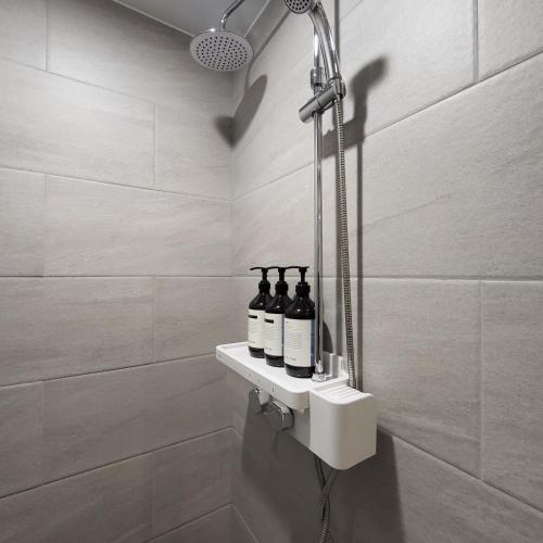 a bathroom with three bottles of wine on a shelf at COVE Stay-611 in Chagyak-to