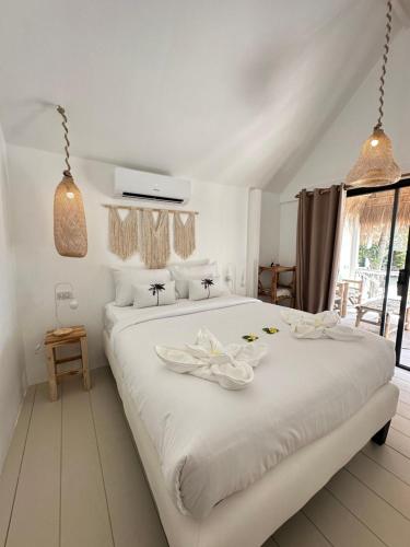 a bedroom with a large white bed with flowers on it at Sama Beach Resort by Munchies Resort in Ban Tai