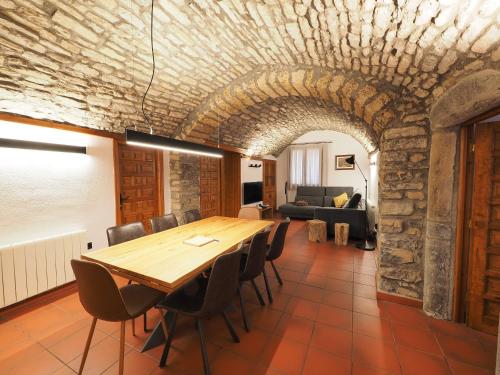a dining room with a table and chairs and a couch at Casa Ara in Boltaña