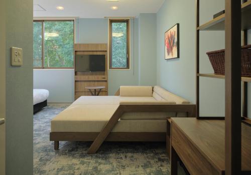 a bedroom with two beds and a television in it at Red 28 in Ito