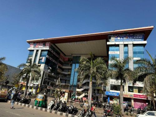 een groot gebouw met palmbomen ervoor bij SPOT ON SBL HOTEL ROOMS in Surat
