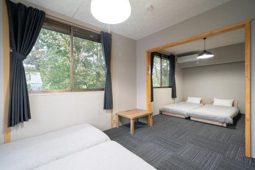a room with two beds and two windows at Vacation Rental NENBA in Hokuto
