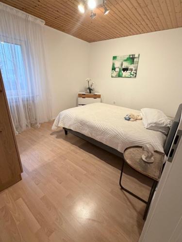 a bedroom with a bed and a table and a window at FerienwohnungNord in Singen