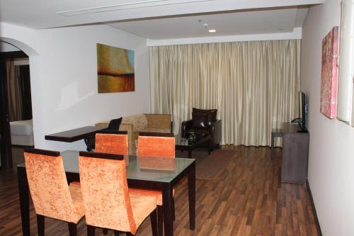a living room with a dining room table and chairs at Golden Tulip Al Khobar Suites in Al Khobar
